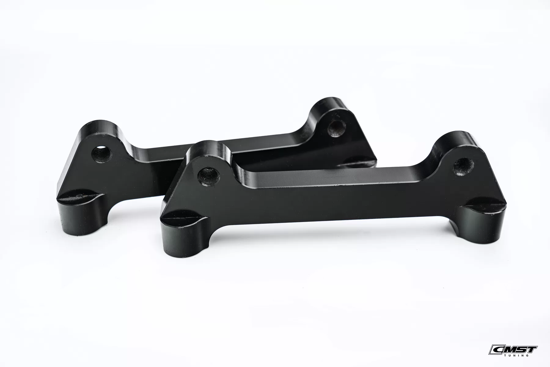 A pair of black-finished CMST caliper adapter brackets